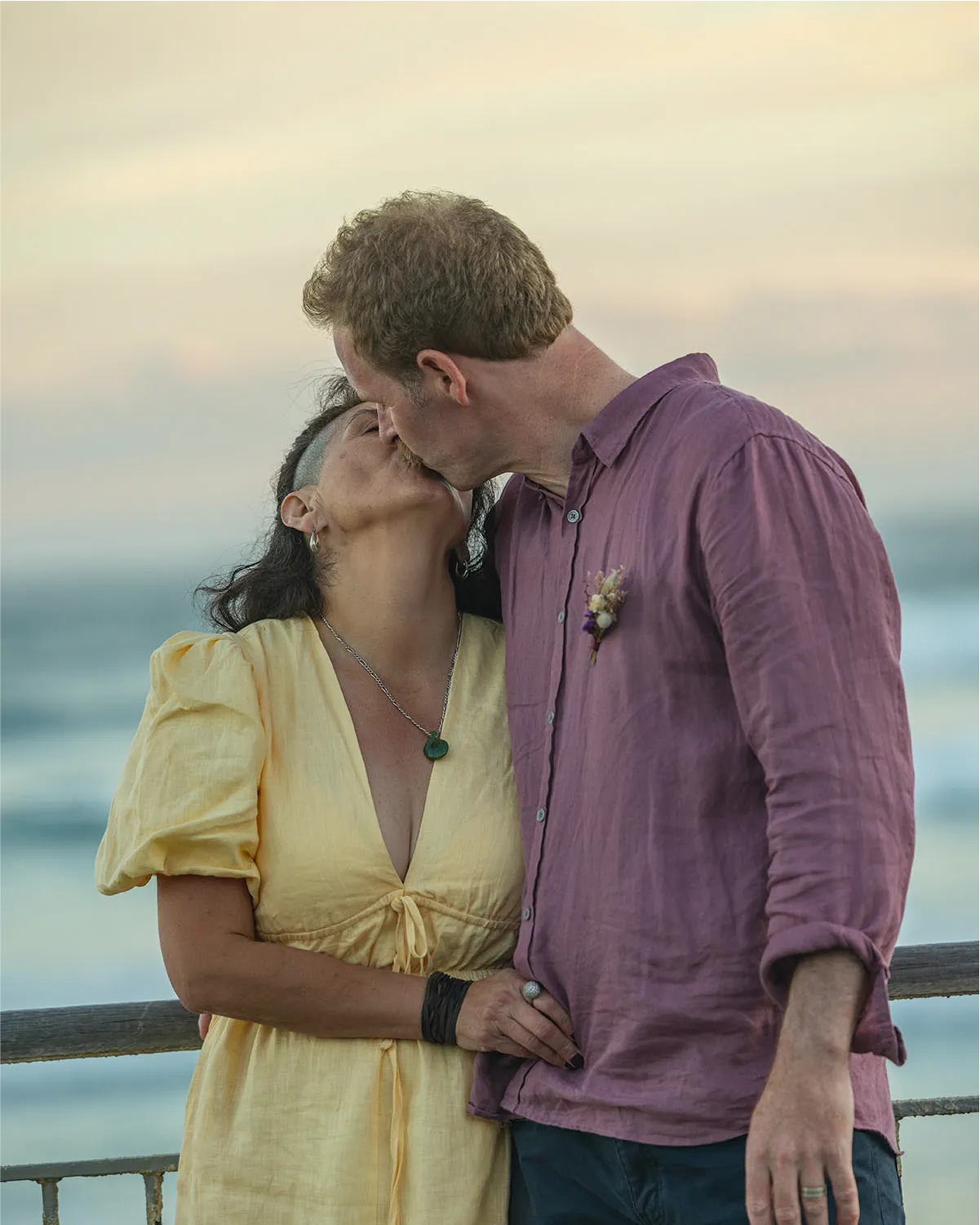 Romantic wedding couple embracing in a sun-drenched New Zealand forest by Vowly Wedding Video Production.