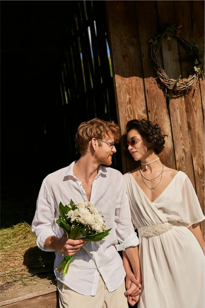 High-angle shot of a wedding couple embracing in a green New Zealand field, Vowly Wedding Video Production.